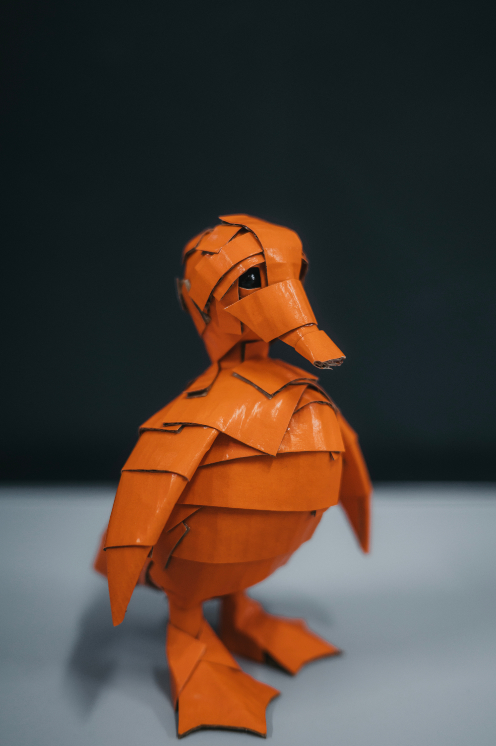 Patito naranja de perfil. Escultura de cartón. Orgaz.