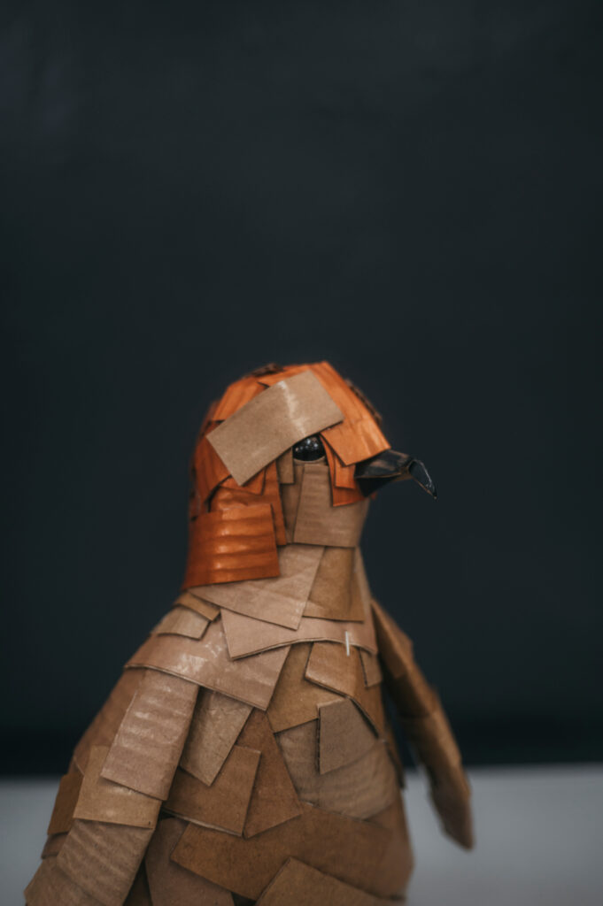 Pingüino naranja tornasol perfil derecho. Escultura de cartón. Orgaz.