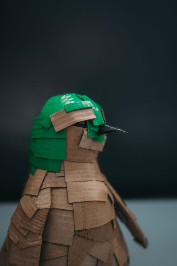 Pingüino verde primer plano de perfil. Cartón y pigmento. Orgaz.