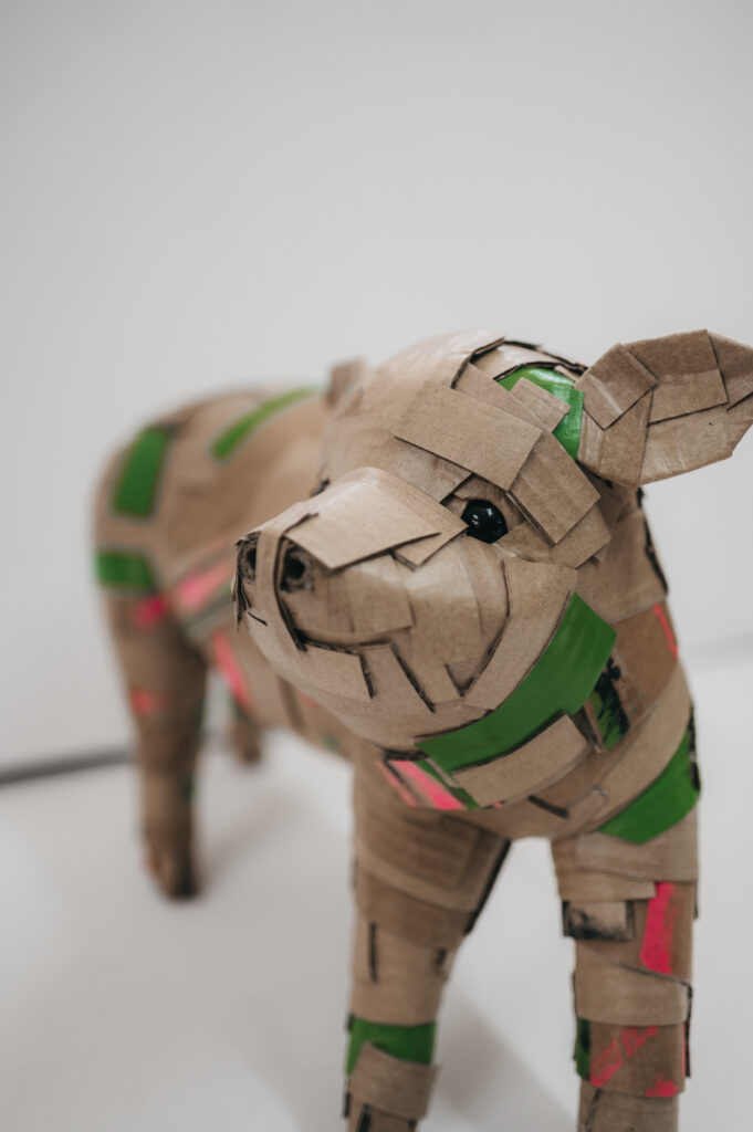 Cerdito en verde de frente. Escultura de cartón. Orgaz