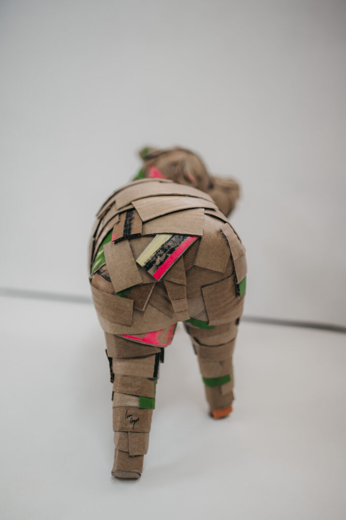 Vista trasera del cerdito verde con rabito. Escultura de cartón. Orgaz