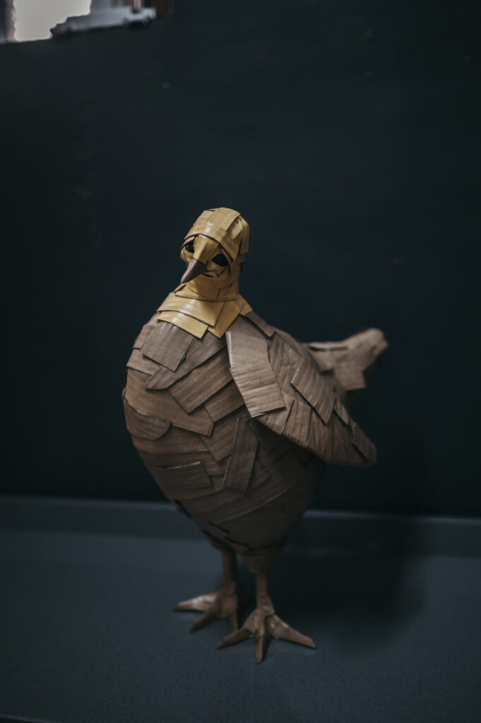 Gallina amarilla de frente, cuerpo entero. Escultura de cartón. Orgaz