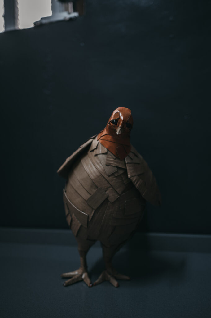 Gallina naranja de frente, cuerpo entero. Escultura de cartón. Orgaz