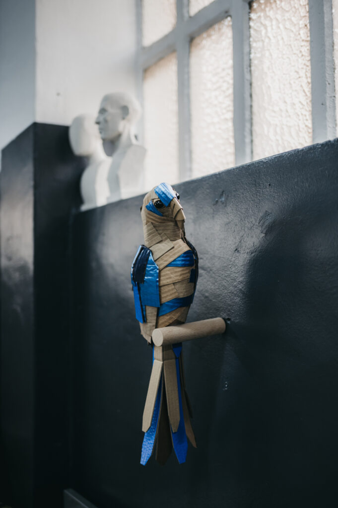 Guacamayo en azules, cuerpo entero. Escultura de cartón. Orgaz