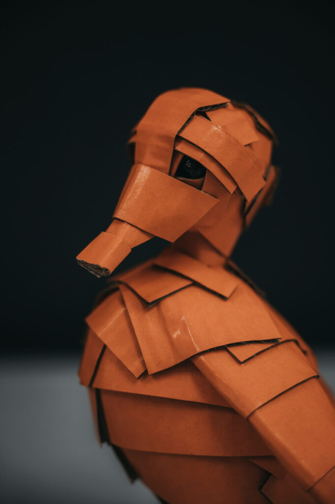 Detalle del patito naranja, perfil izquierdo. Escultura de cartón. Orgaz