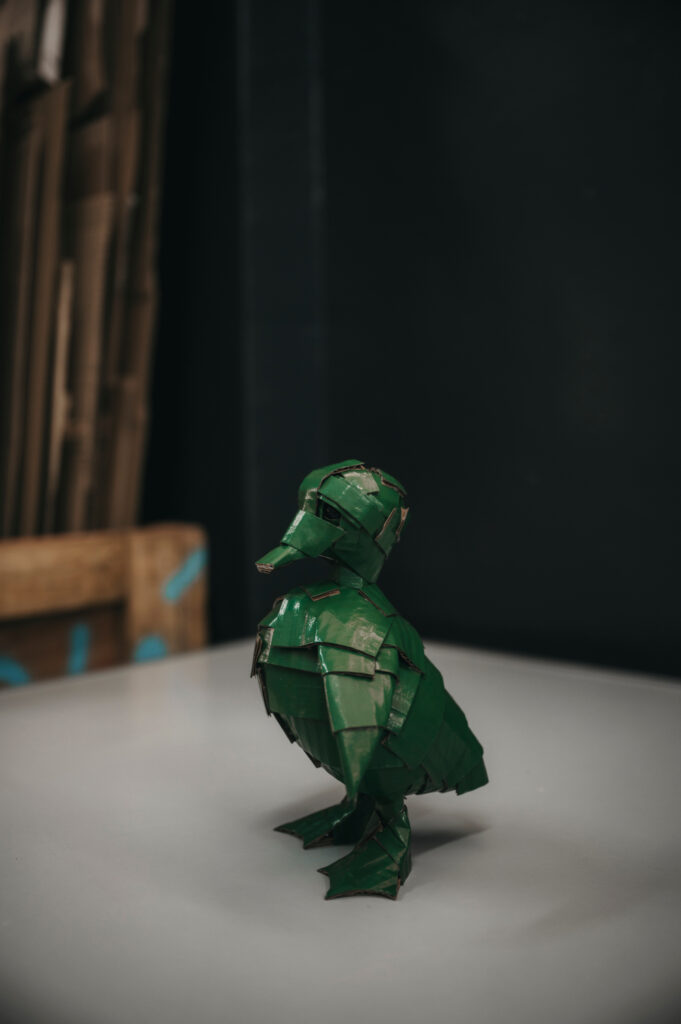 Patito verde inglés entero de perfil. Escultura de cartón. Orgaz