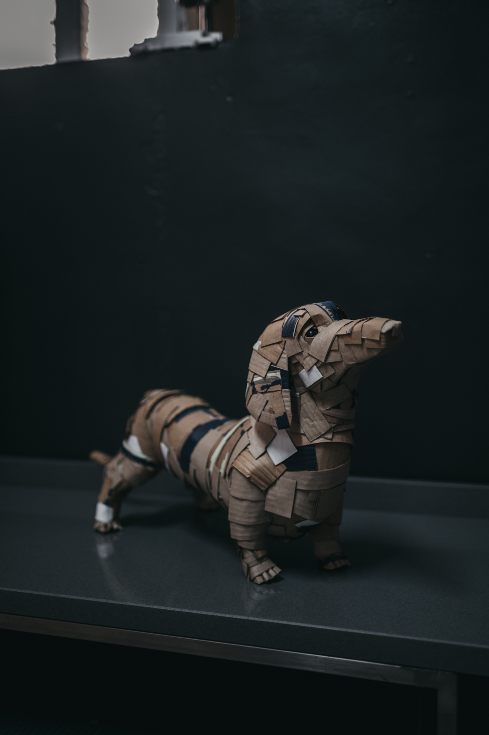 Teckel de frente, cuerpo entero. Escultura de cartón. Orgaz