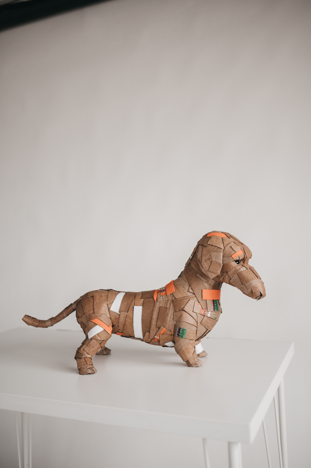 Teckel naranja de perfil, cuerpo entero. Escultura de cartón. Orgaz