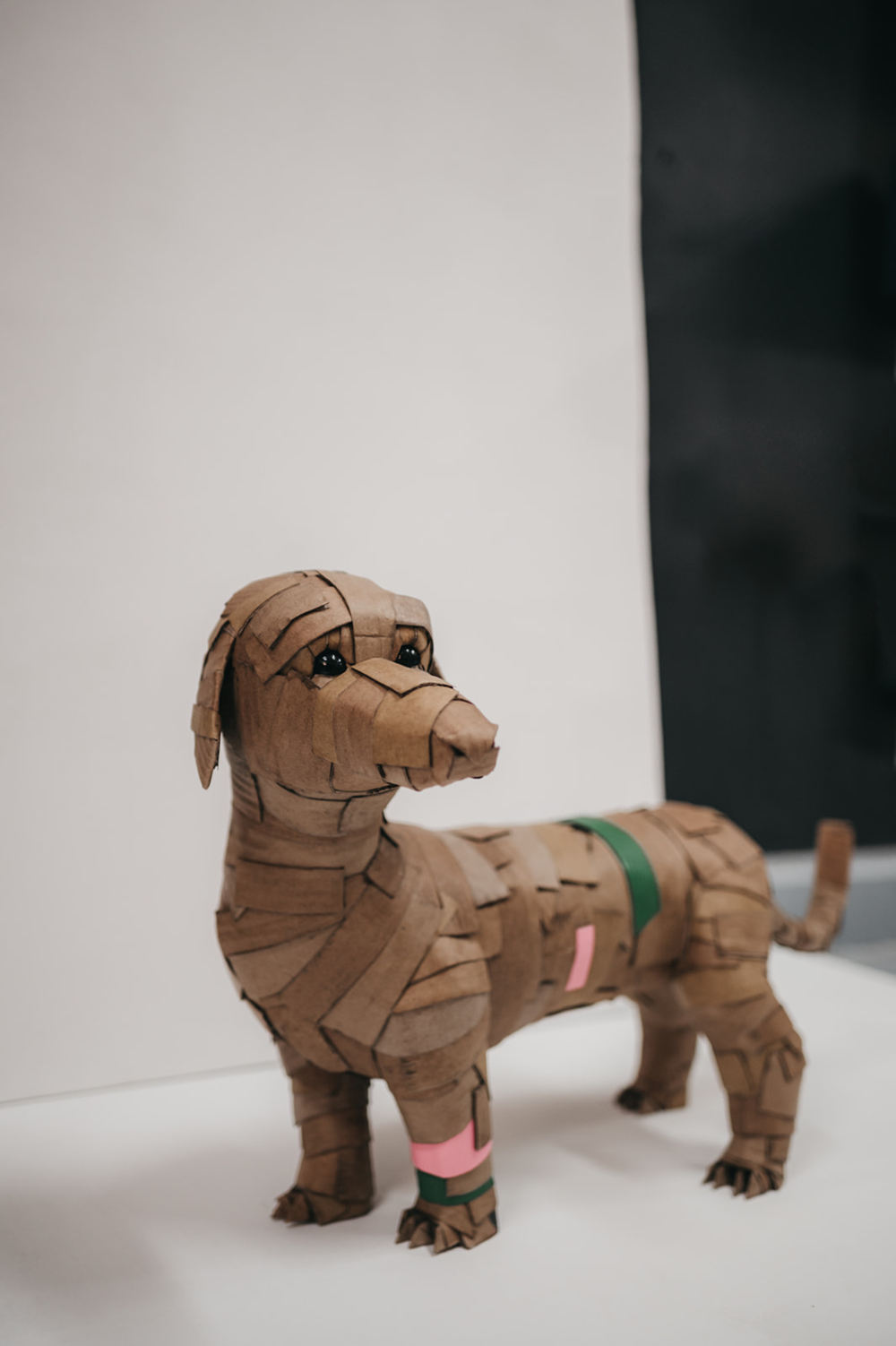 Teckel rosa y verde, cuerpo entero. Escultura de cartón. Orgaz